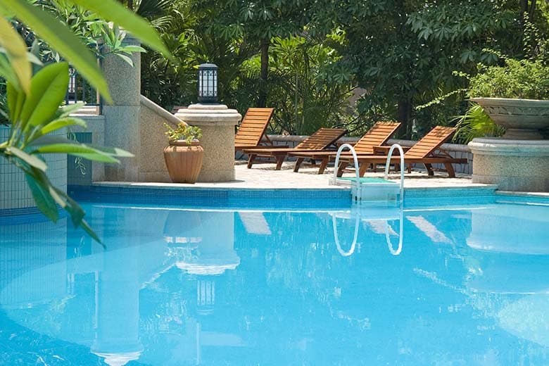 Outdoor swimming pool with sea ocean beach around umbrella and chair for leisure travel vacation