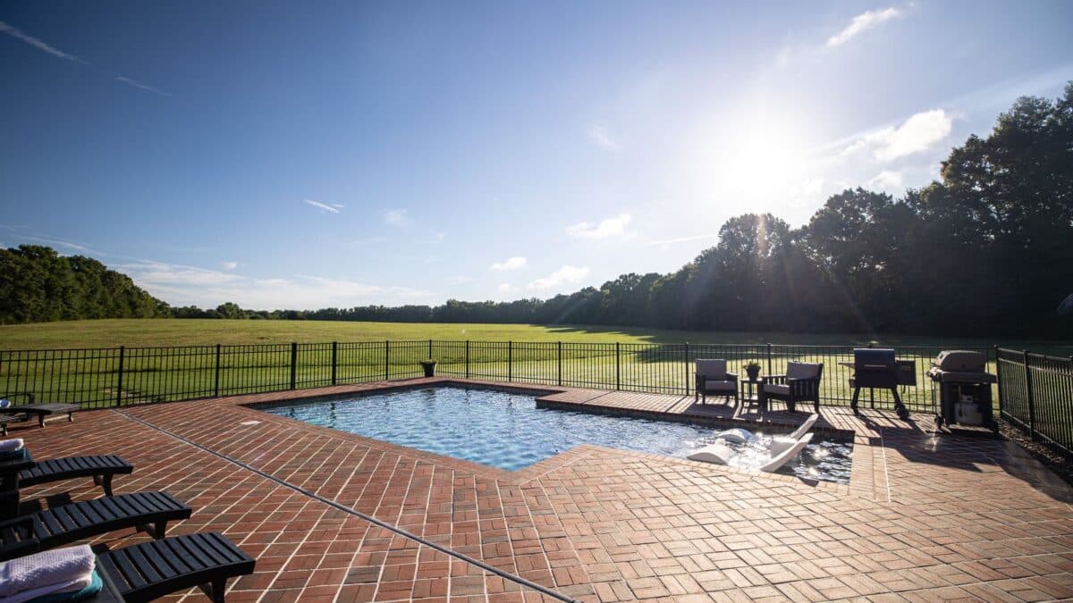 Pool in backyard with a view of the open grass area