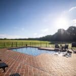 Pool in backyard with a view of the open grass area