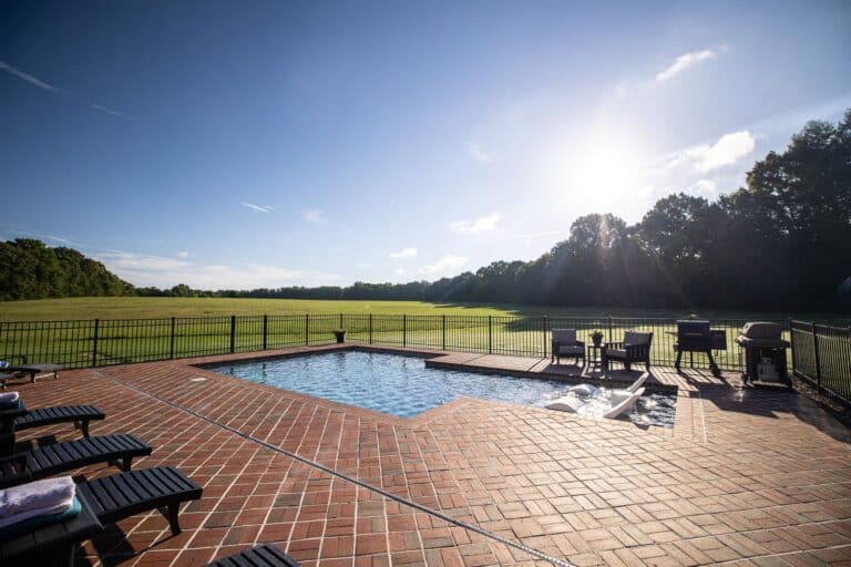 Pool in backyard with a view of the open grass area