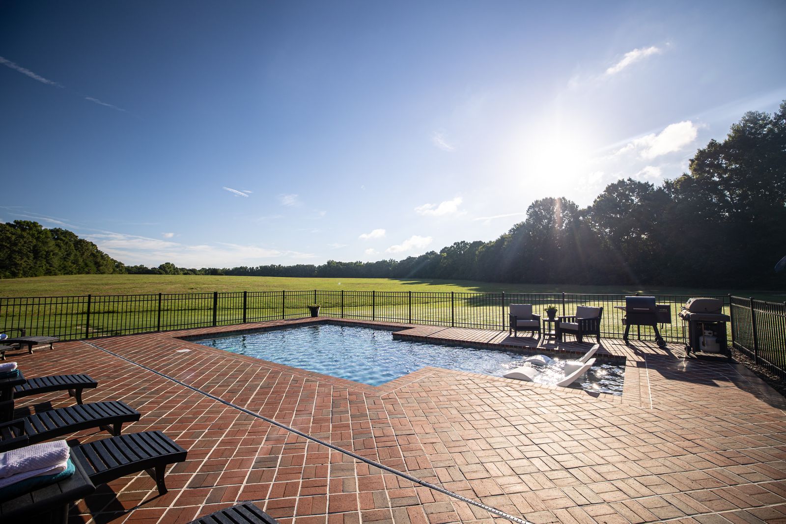 Pool in backyard with a view of the open grass area